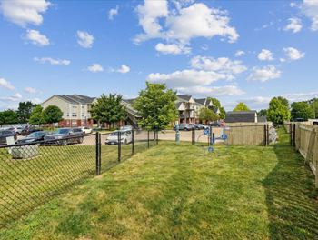 the view of a fenced in yard with apartments in the background